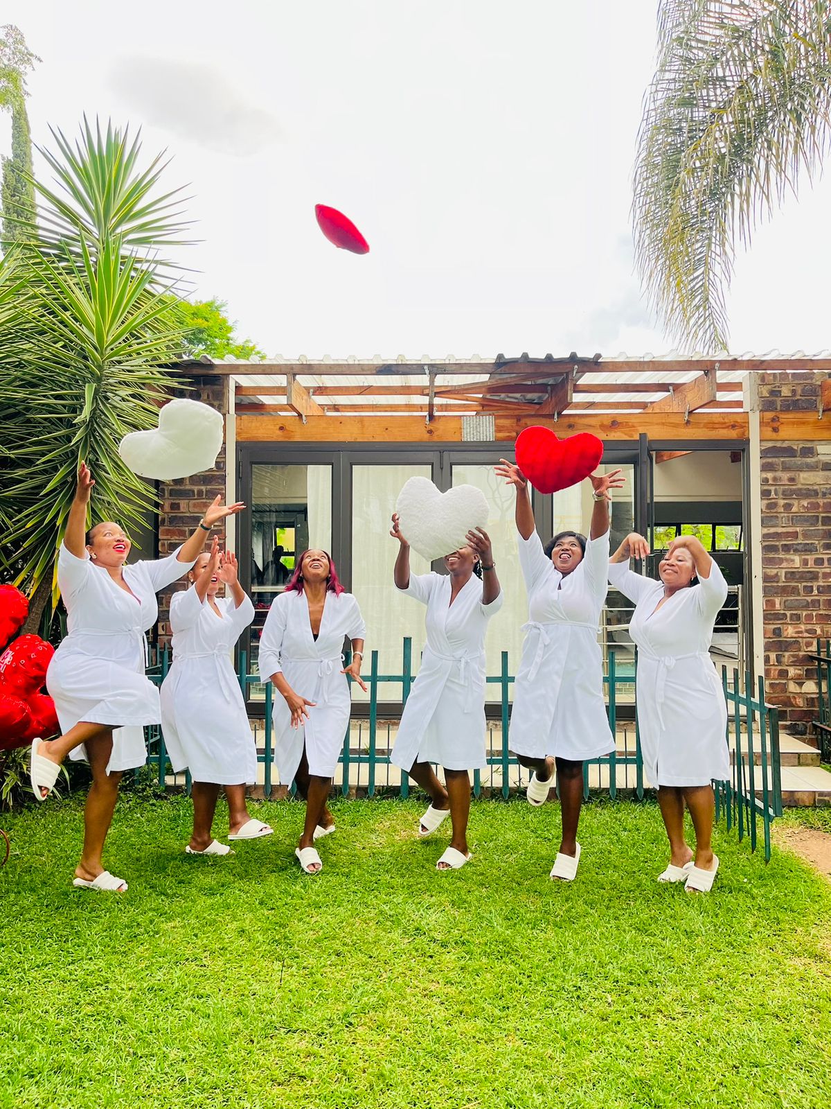 Group celebrating by throwing heart cushions.